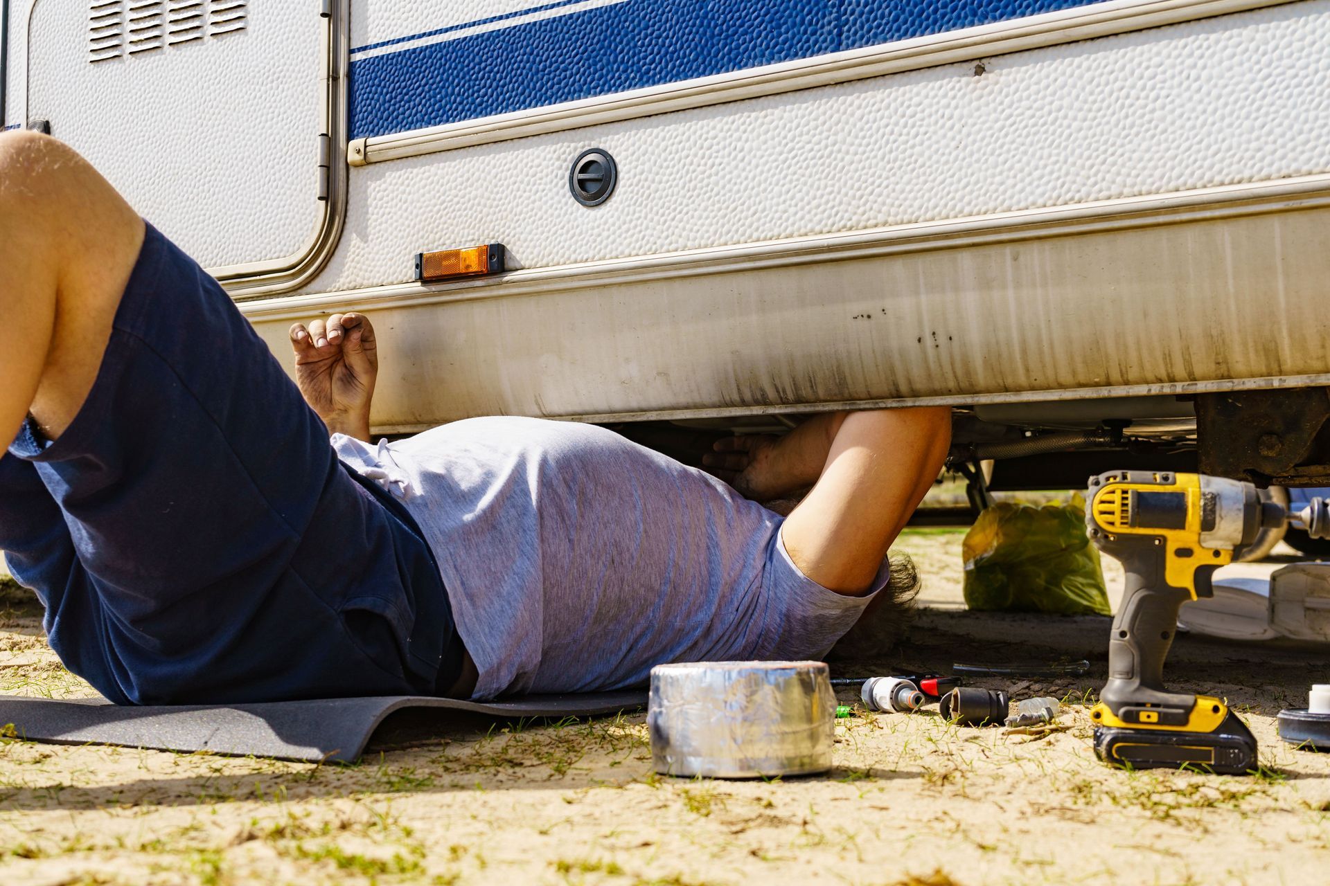 Technician repairing the bottom of the RV caravan. Technician repairing the bottom of the RV caravan.