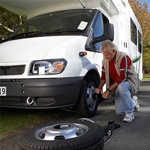 RV Body Repair Services — Man Fixing Tire in Santa Cruz,CA