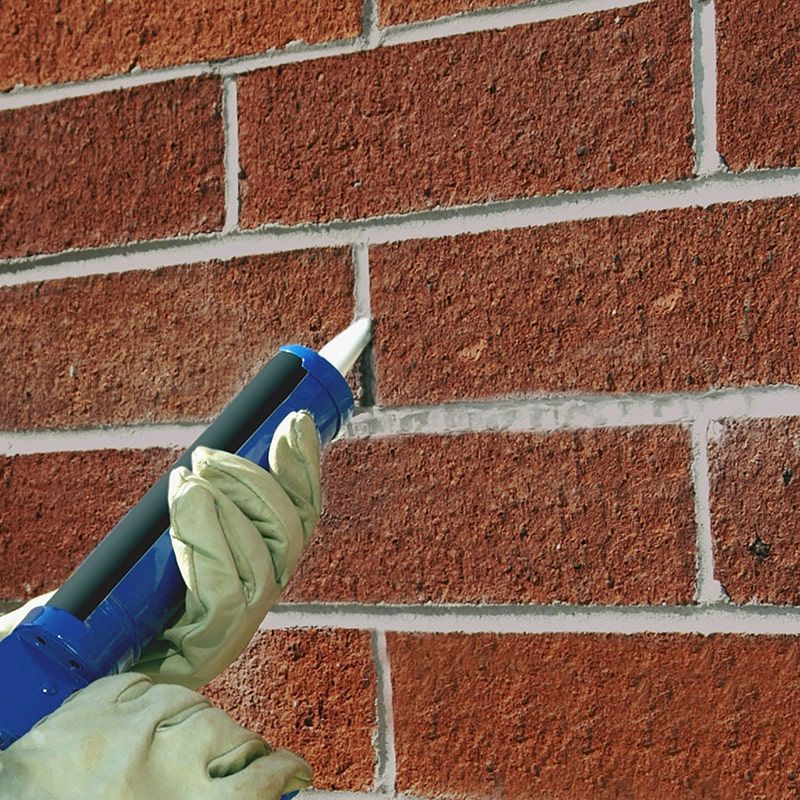 Un bâtiment en briques rouges avec une clôture en bois devant.