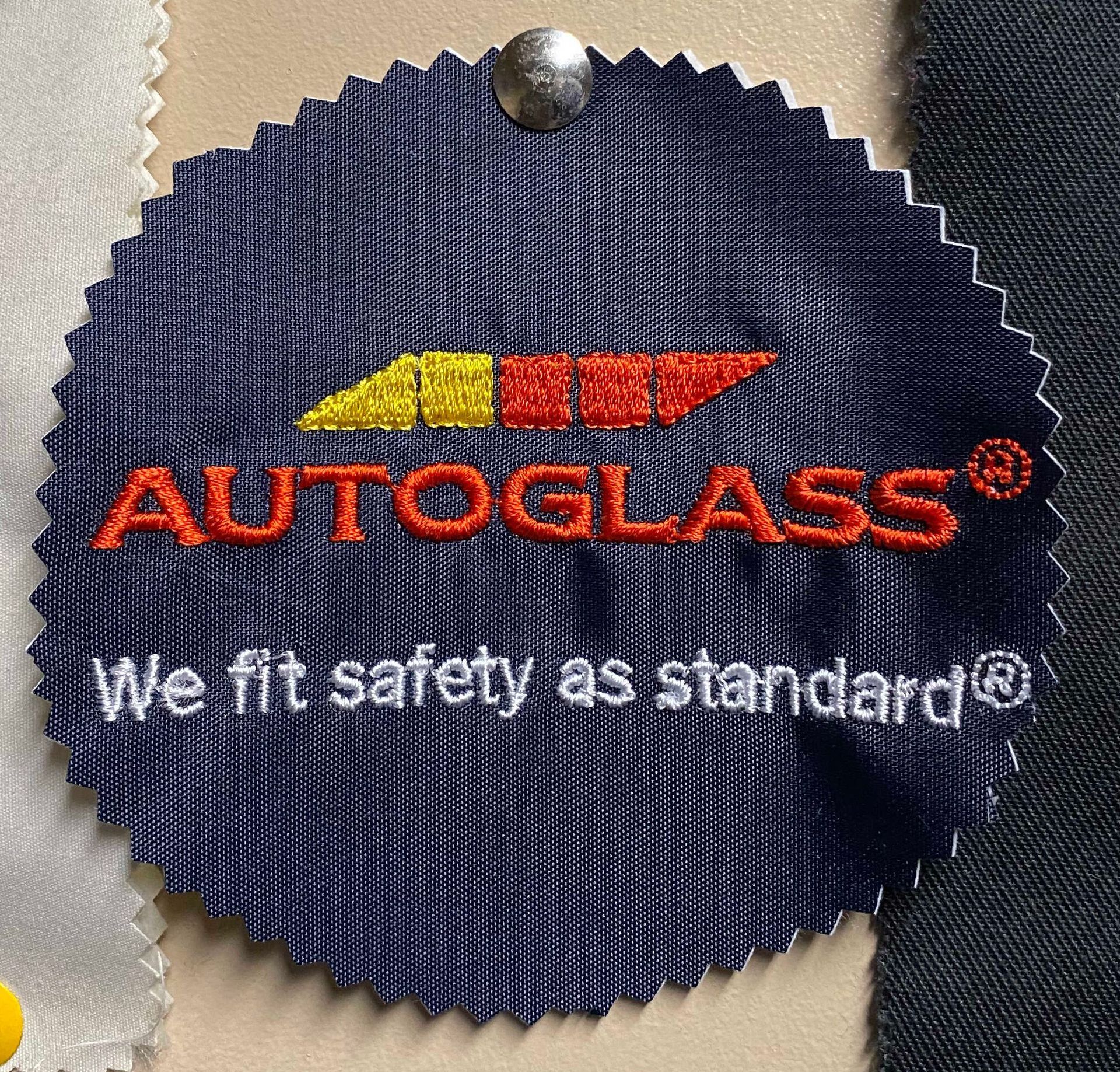 Circular blue fabric tag with embroidered