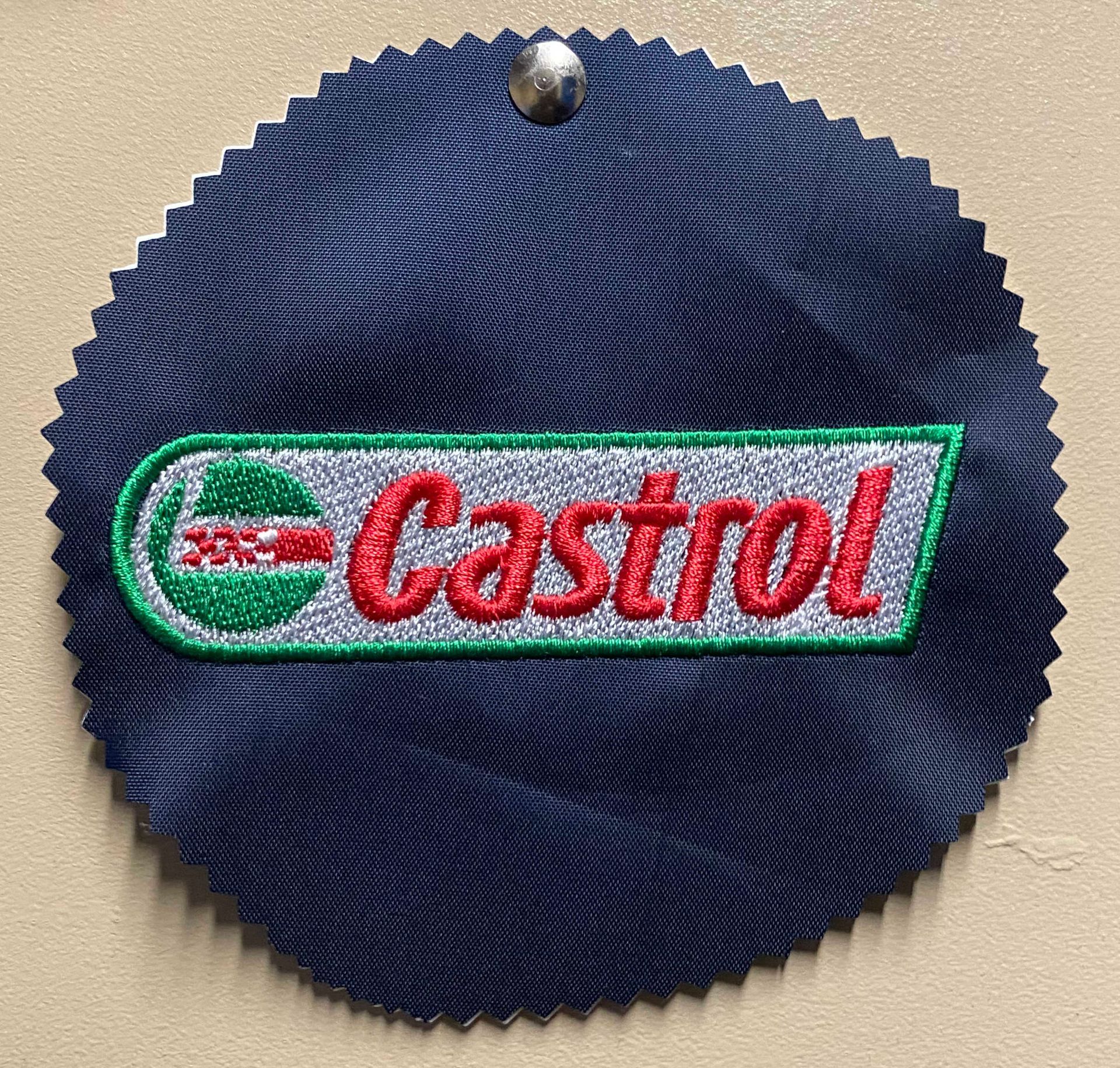 Castrol logo embroidered on a navy blue, circular swatch. The logo has a green and red design.