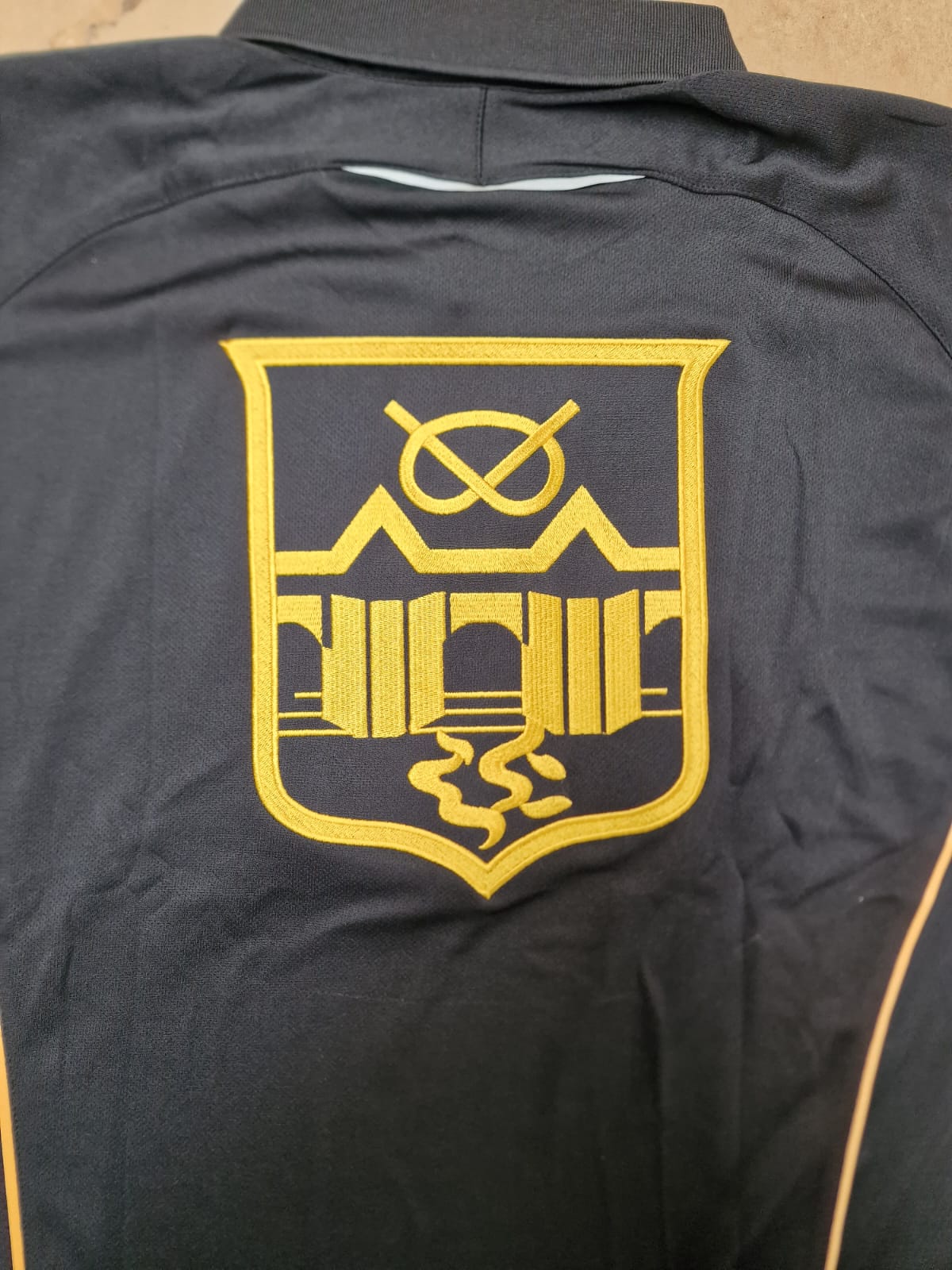 Black shirt with gold embroidered crest for King Edward VI Grammar School located in Handsworth.