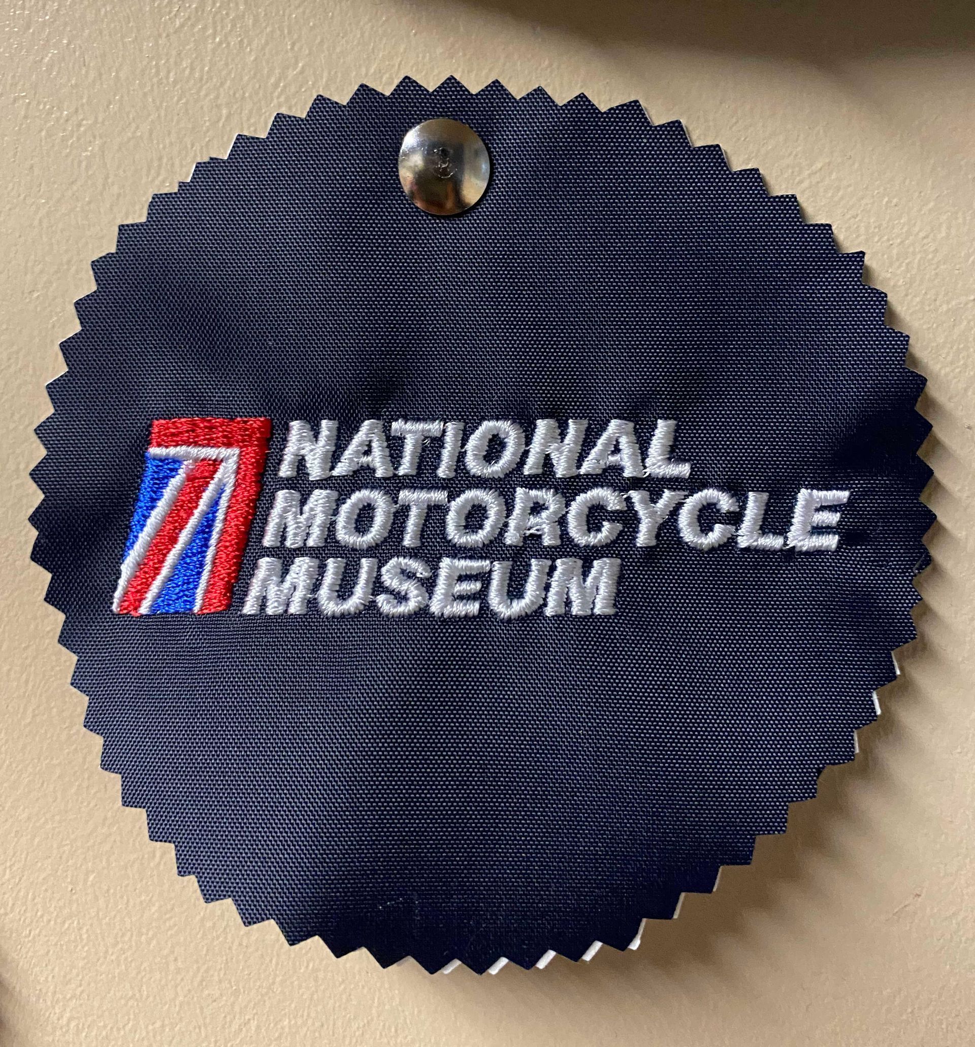 National Motorcycle Museum. The logo includes the museum's name and a stylized red, white, and blue design, all embroidered.