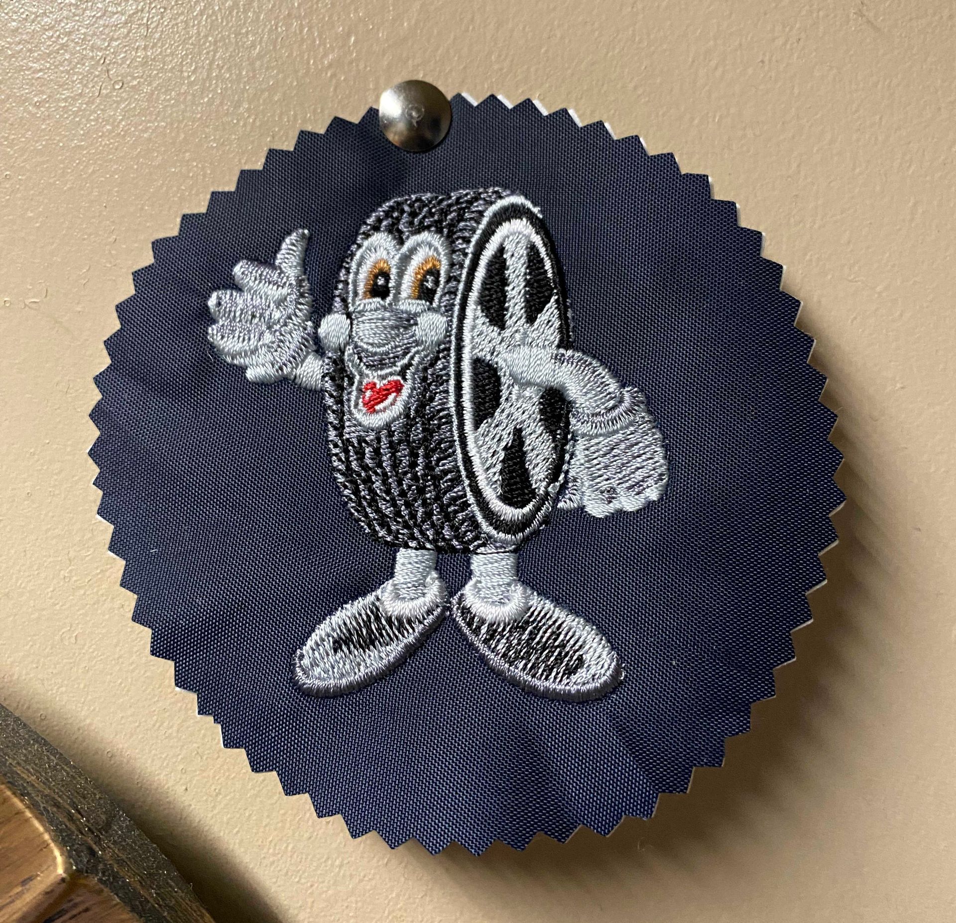 An embroidered patch of the National Tyres logo on a blue background.