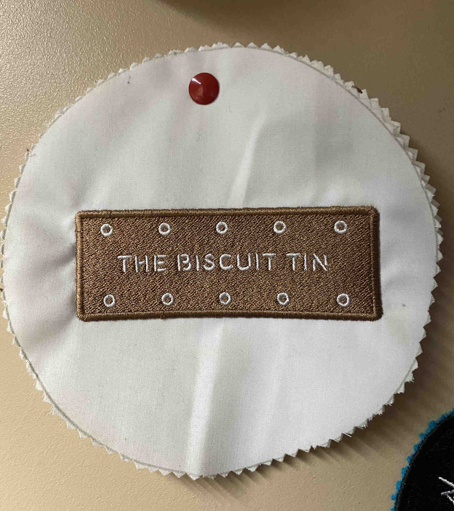 A embroidered brown rectangular patch that reads