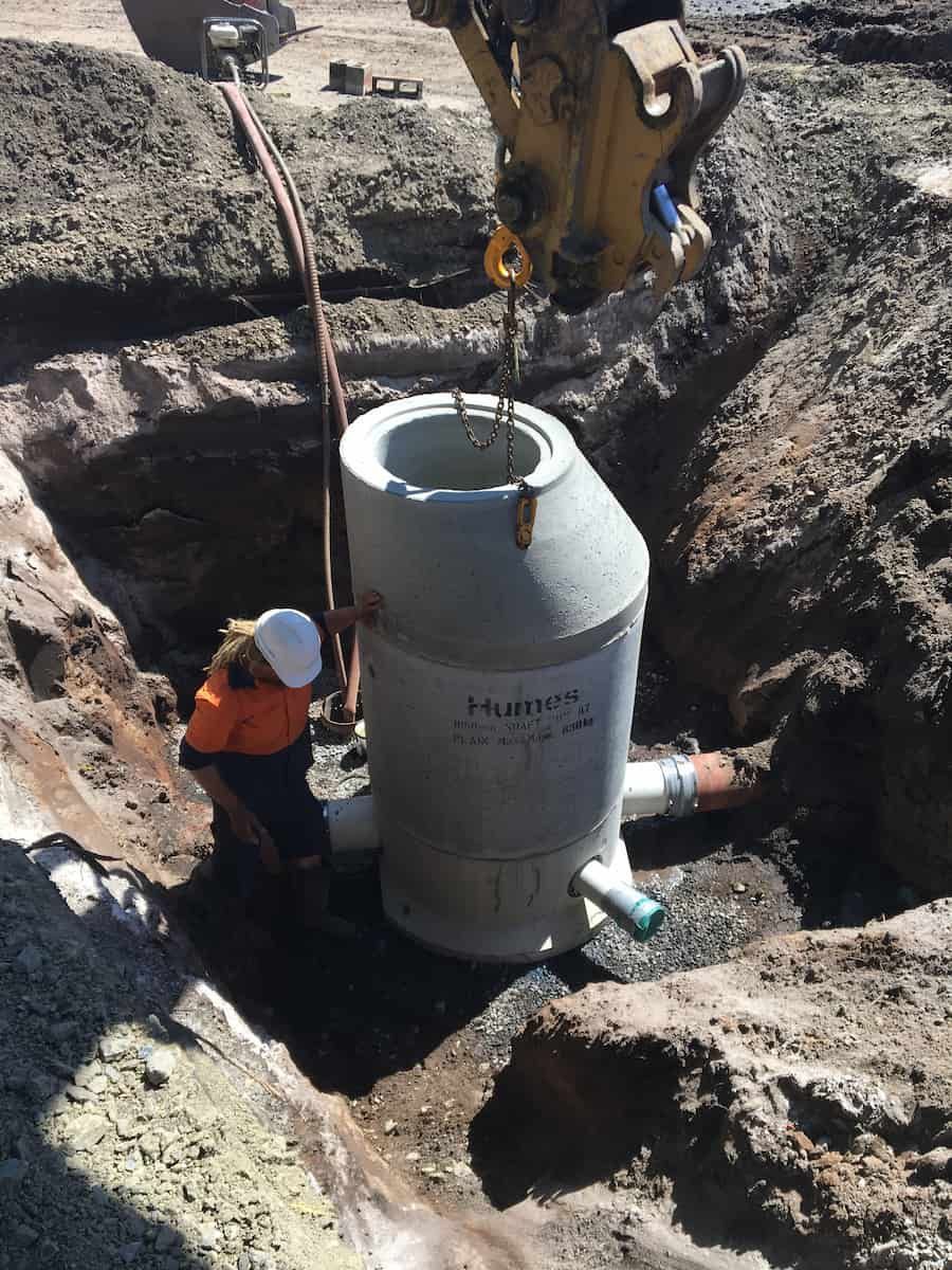 A Man Is Standing Next To A Large Concrete Cylinder In A Hole — J & M Bashforth & Sons In Brunswick Heads, NSW