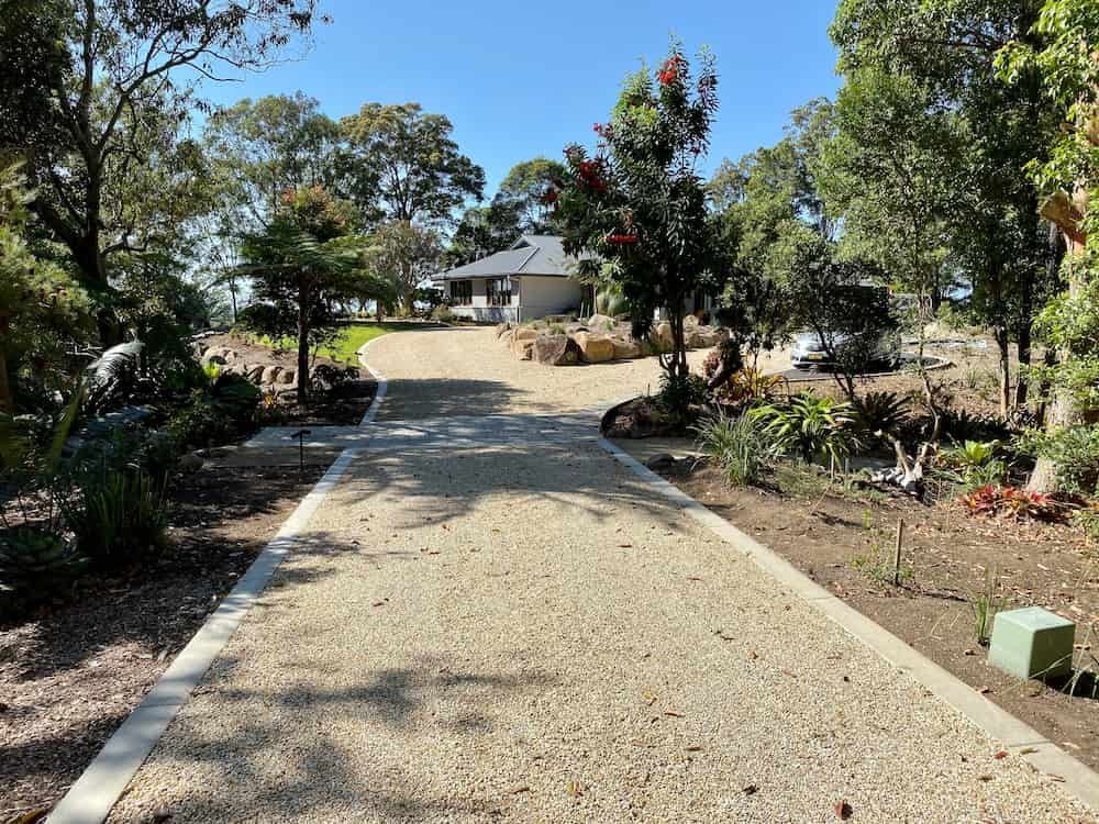 A Gravel Driveway Leading To A House Surrounded By Trees — J & M Bashforth & Sons In Brunswick Heads, NSW