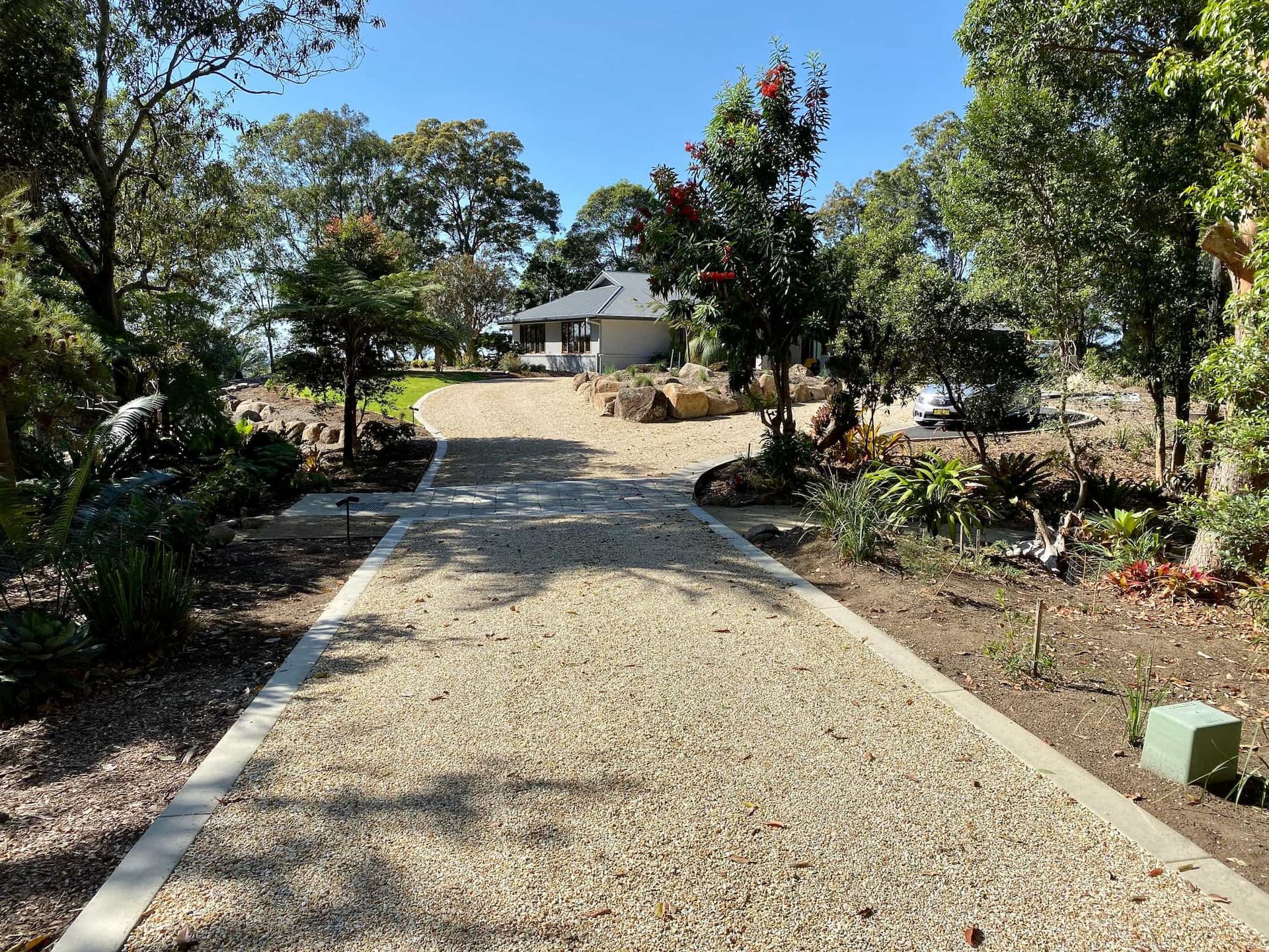 A Gravel Driveway Leading to A House Surrounded by Trees — J & M Bashforth & Sons In Casino, NSW
