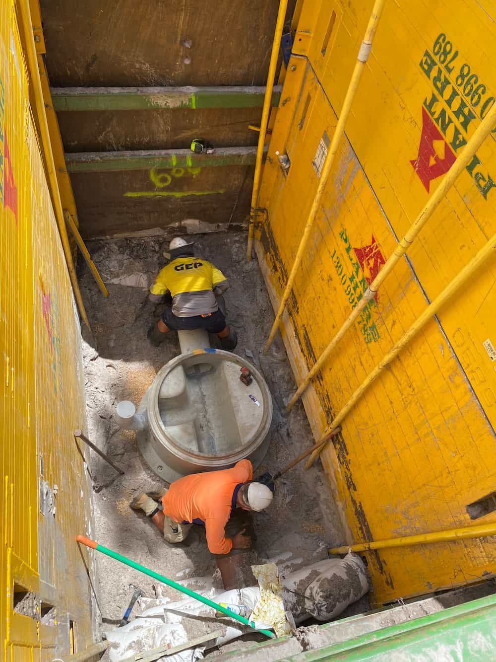 A Man Is Working On A Pipe In A Hole In The Ground — J & M Bashforth & Sons In Brunswick Heads, NSW
