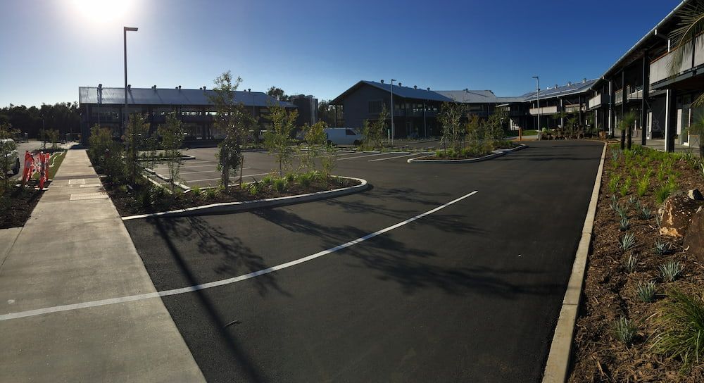 A Parking Lot With A Building In The Background — J & M Bashforth & Sons In Brunswick Heads, NSW