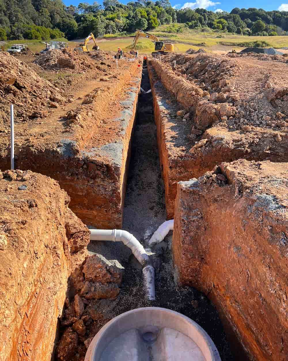 A Pipe Is Being Installed In A Trench In The Dirt — J & M Bashforth & Sons In Brunswick Heads, NSW