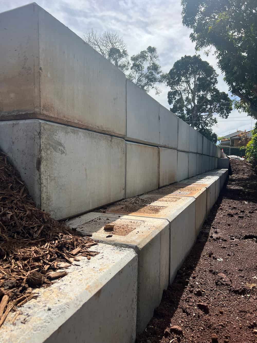 A Concrete Wall Is Being Built In A Yard With Trees In The Background — J & M Bashforth & Sons In Brunswick Heads, NSW