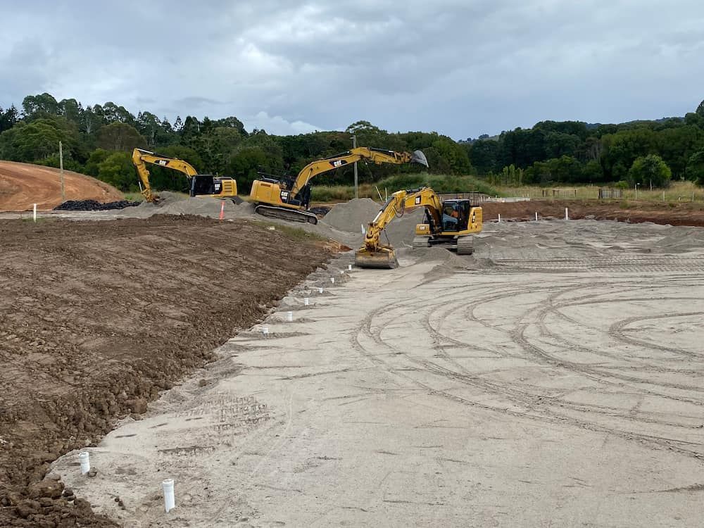 A Group Of Construction Vehicles Are Working On A Dirt Field — J & M Bashforth & Sons In Brunswick Heads, NSW