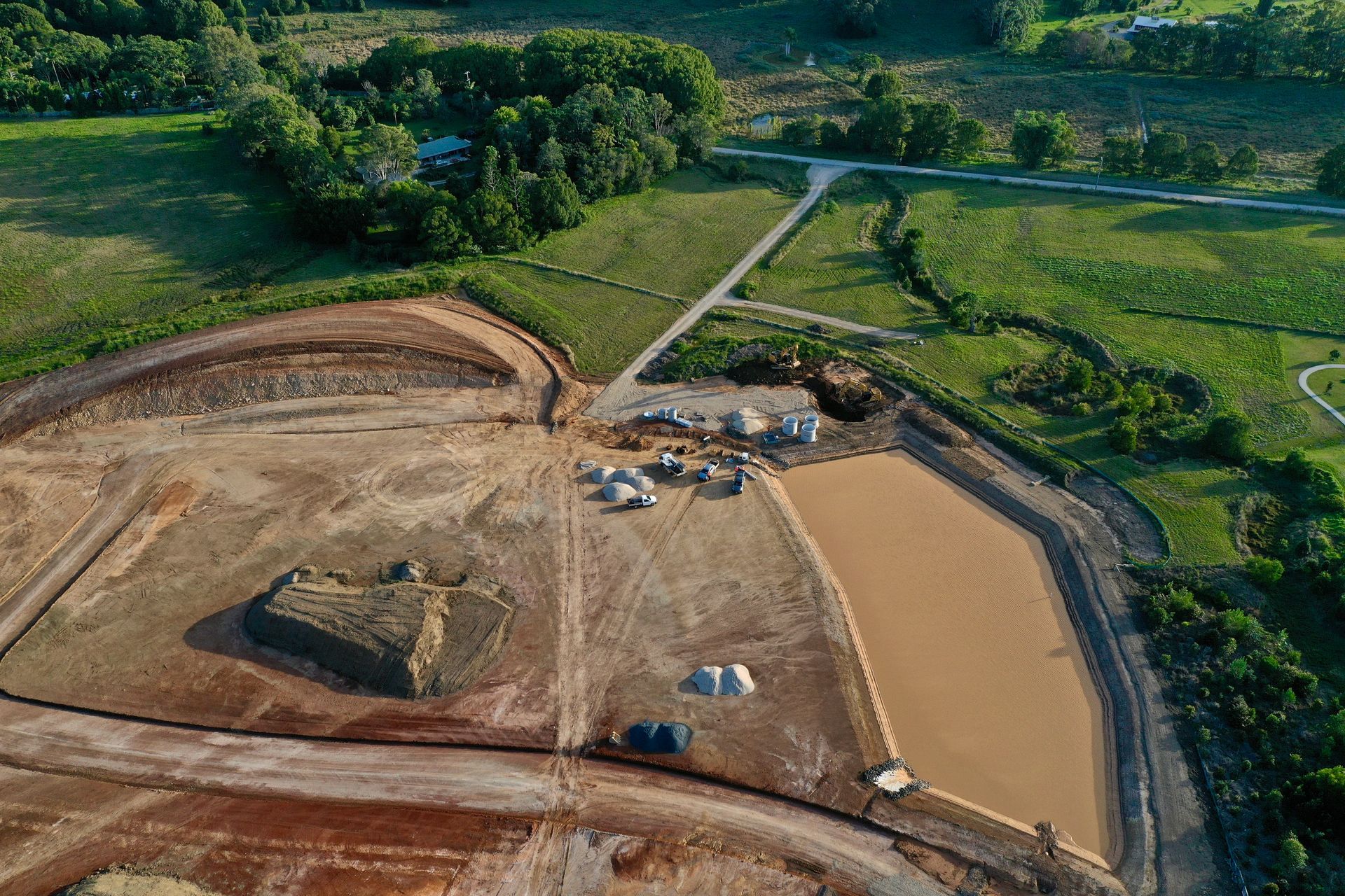 An Aerial View Of A Large Dirt Field With Trees And A Lake — J & M Bashforth & Sons In Brunswick Heads, NSW