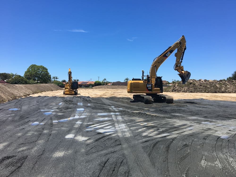 A Couple Of Excavators Are Sitting On Top Of A Dirt Field — J & M Bashforth & Sons In Brunswick Heads, NSW