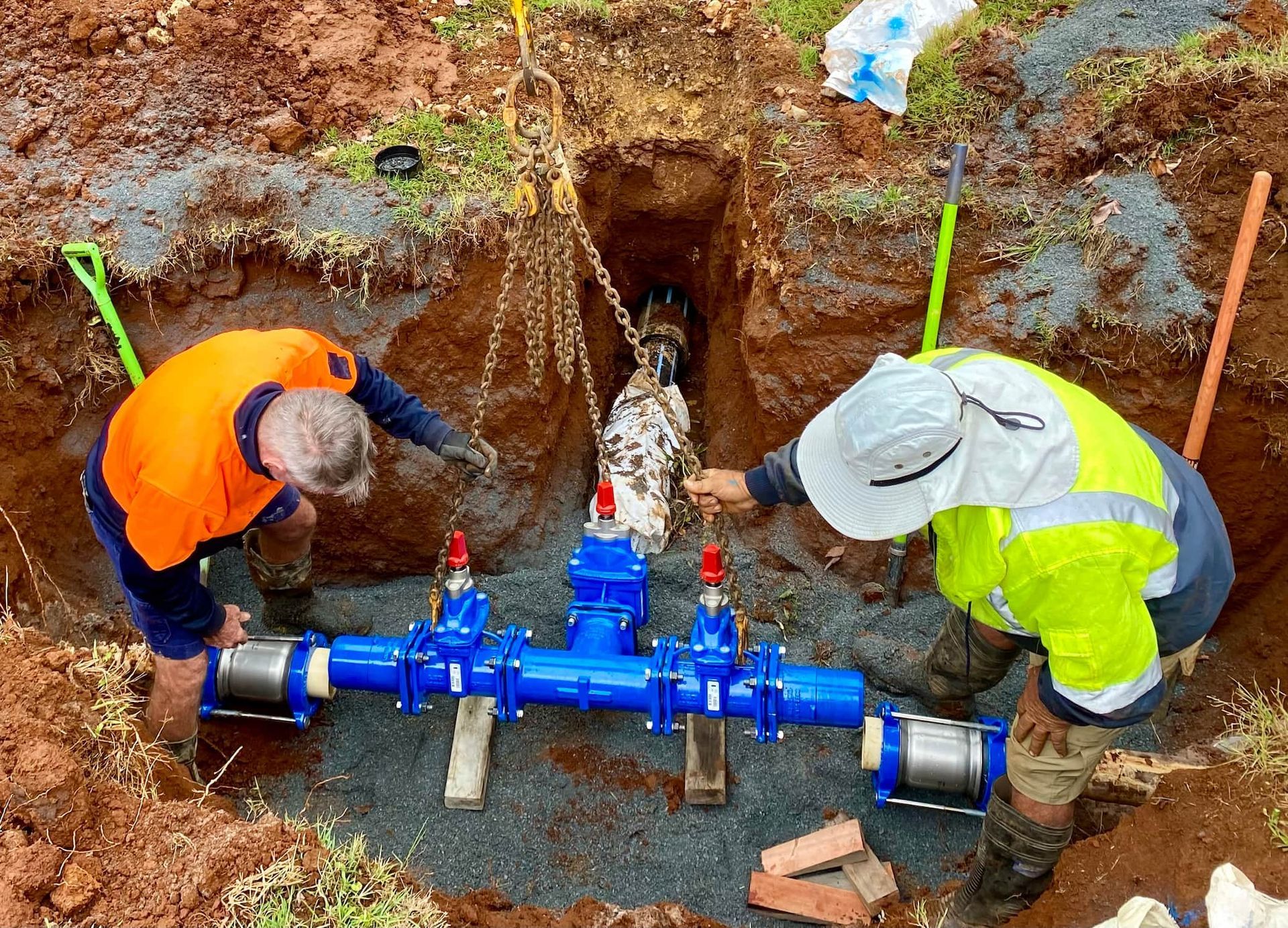 Two Men Are Working on A Pipe in The Dirt — J & M Bashforth & Sons In Evans Head, NSW
