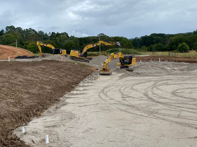 Two Yellow Excavators Are Working in A Dirt Field — J & M Bashforth & Sons In Ballina, NSW