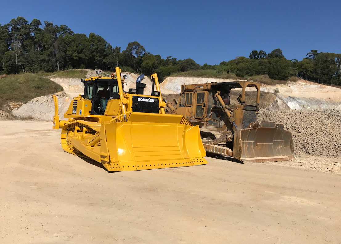 Two Trucks Are Parked In A Dirt Field — J & M Bashforth & Sons In Brunswick Heads, NSW
