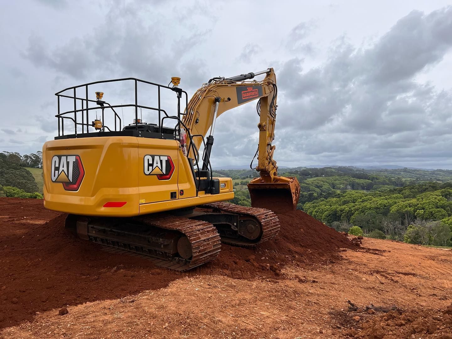 Yellow Excavator Digging Reddish-Brown Earth Hill Landscape