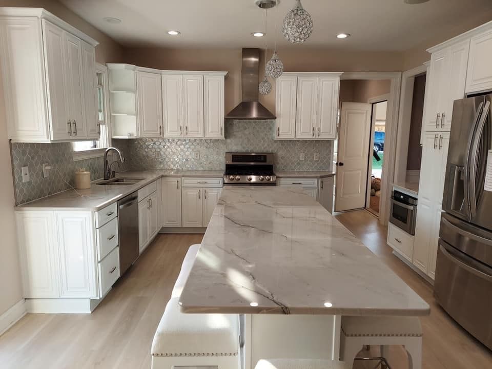 White cabinets, grey granite countertops and new light fixtures for a kitchen remodel