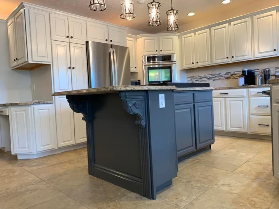 Blue kitchen island with white cabinets, new tiles with decorative woodwork, and ogee edge countertops for a kitchen remodel