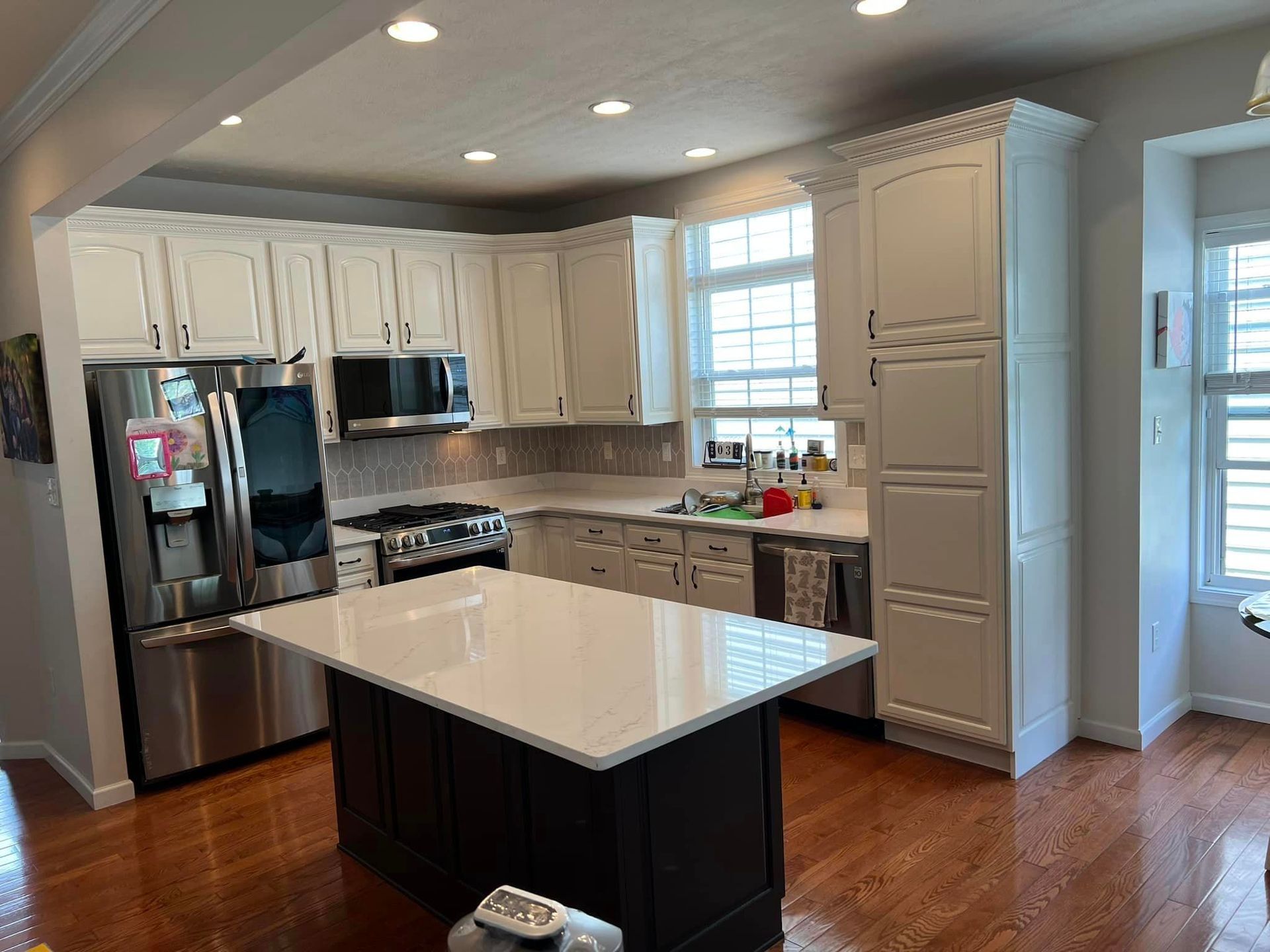 kitchen remodel with wood floors,  cream cabinets, and white granite countertops