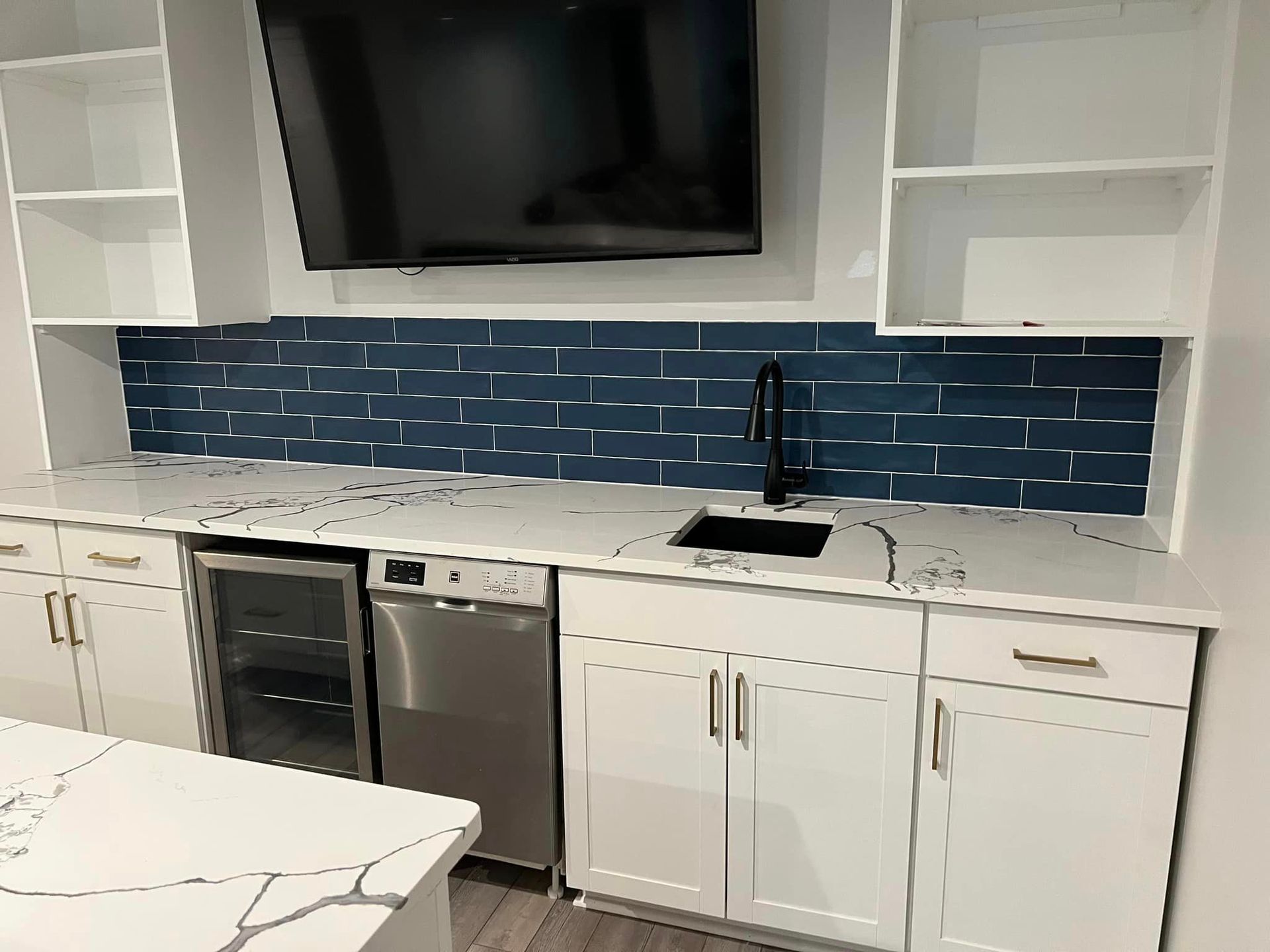 white granite kitchen counter with white shaker cabinets and a blue backsplash for a ktichen remodel in pittsburgh
