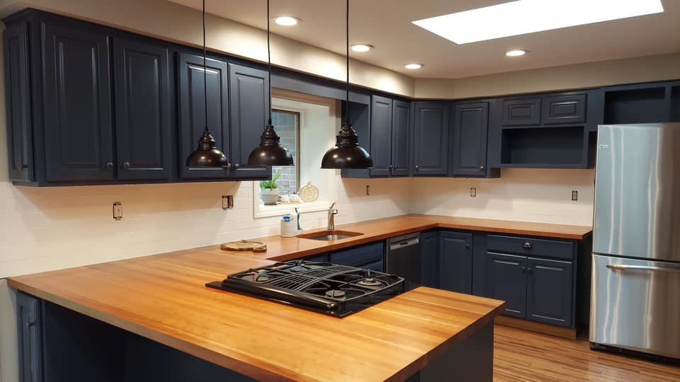 Butcher block countertop with a new range, and white subway tile backsplash and dark blue cabinets as a part of Pittsburgh kitchen remodel