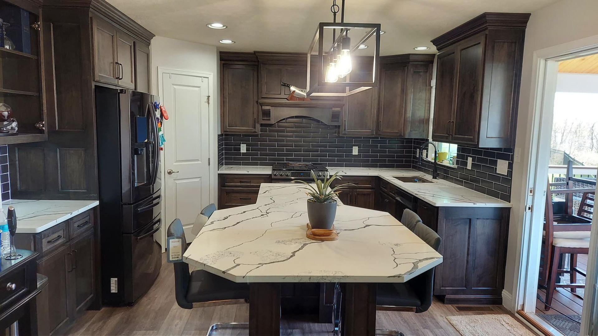 kitchen remode with vinyl plank floor, granite countertops, unique shaped island. Backsplash and dark cabinets