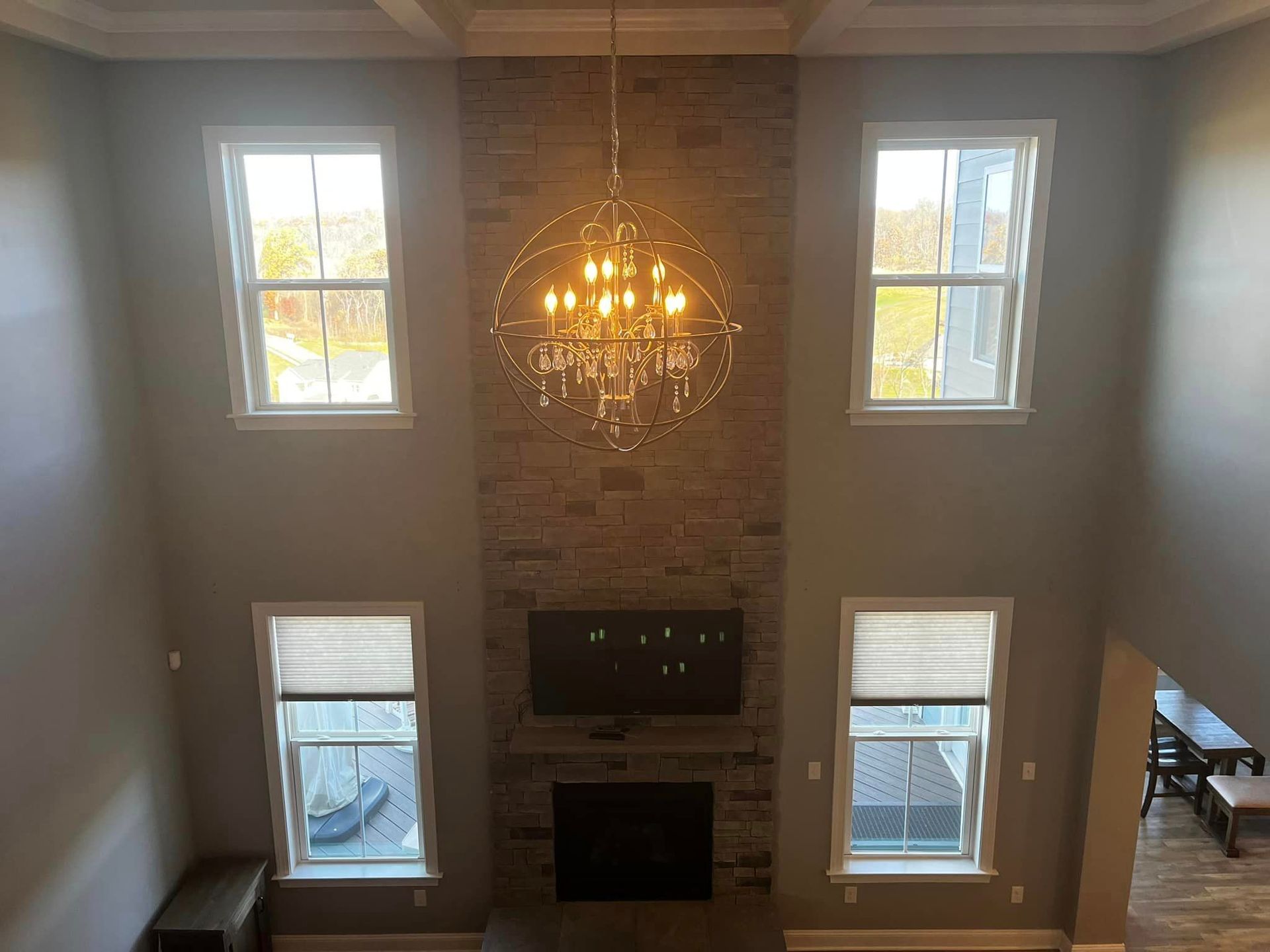 house interior overlooking living room with large chandelier. Two stories indoors painted by Obringers