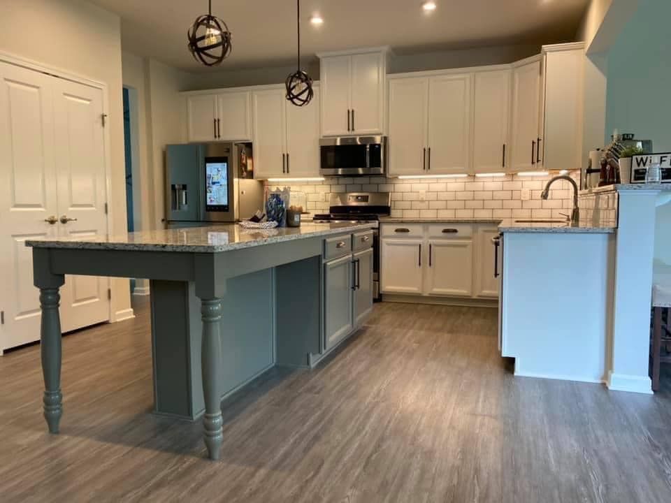 grey island with white cabinets and new countertops lit with new light fixtures