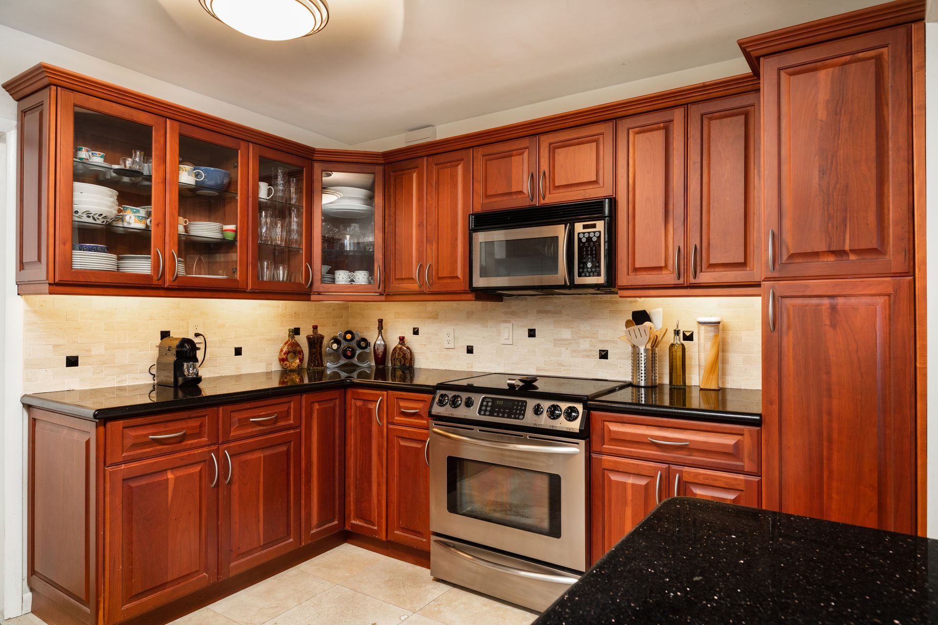 a traditional style kitchen with reddish stained cabinets.