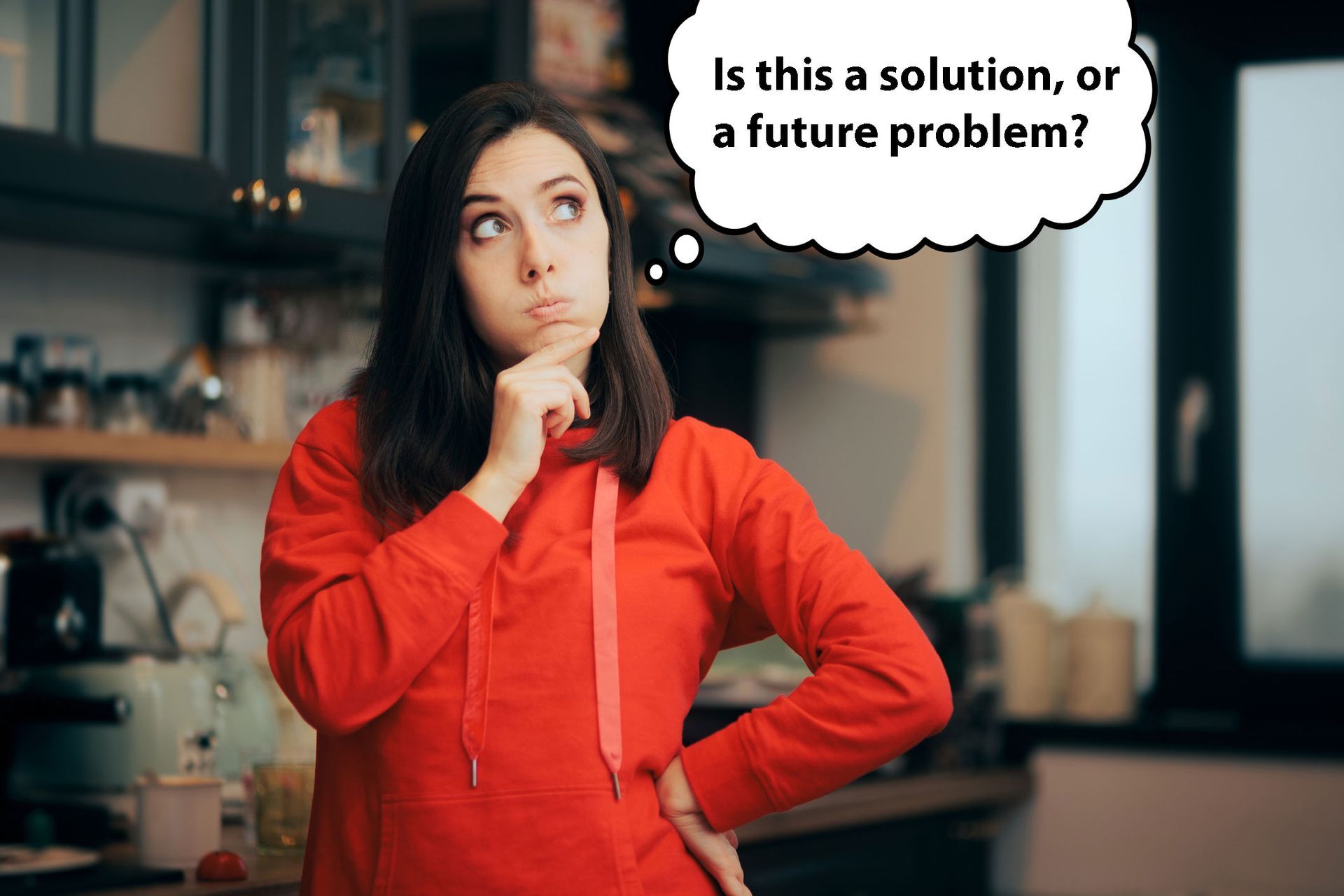 woman in her kitchen with an inquisitive look as she ponders kitchen remodeling