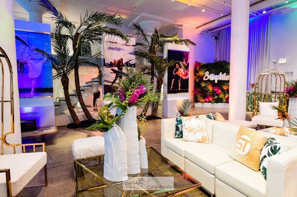 A living room filled with furniture and palm trees.