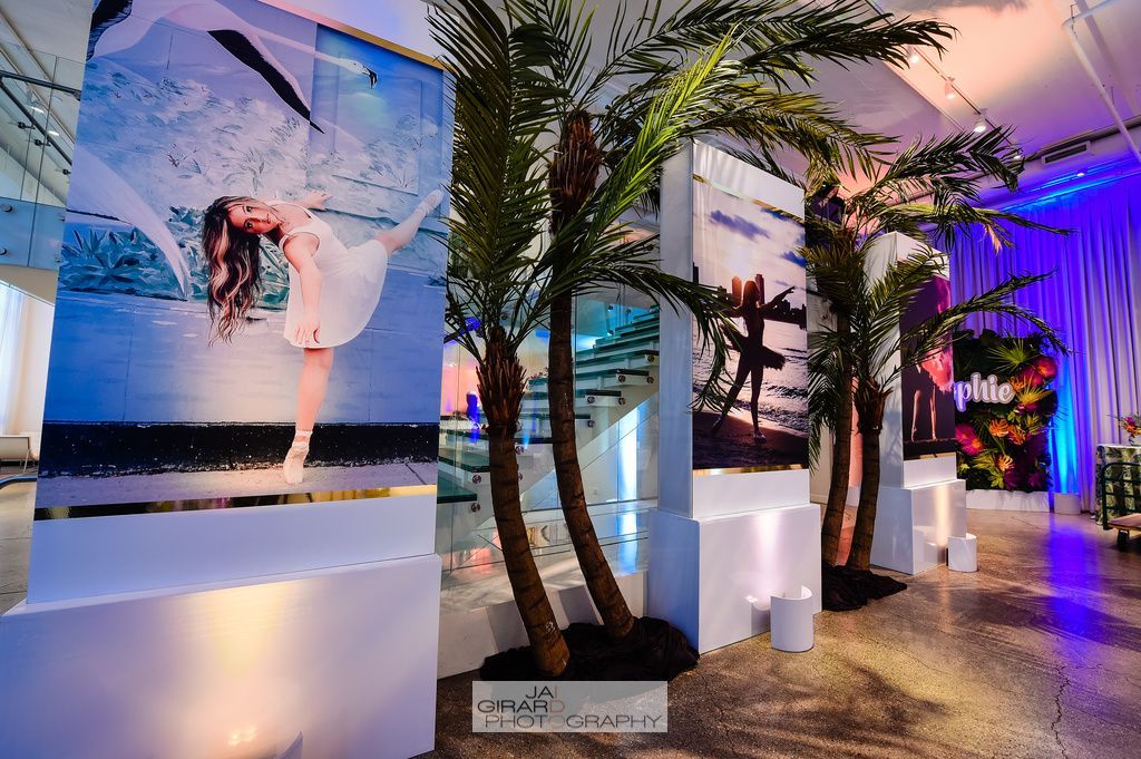 A room with a lot of palm trees and pictures on the wall.