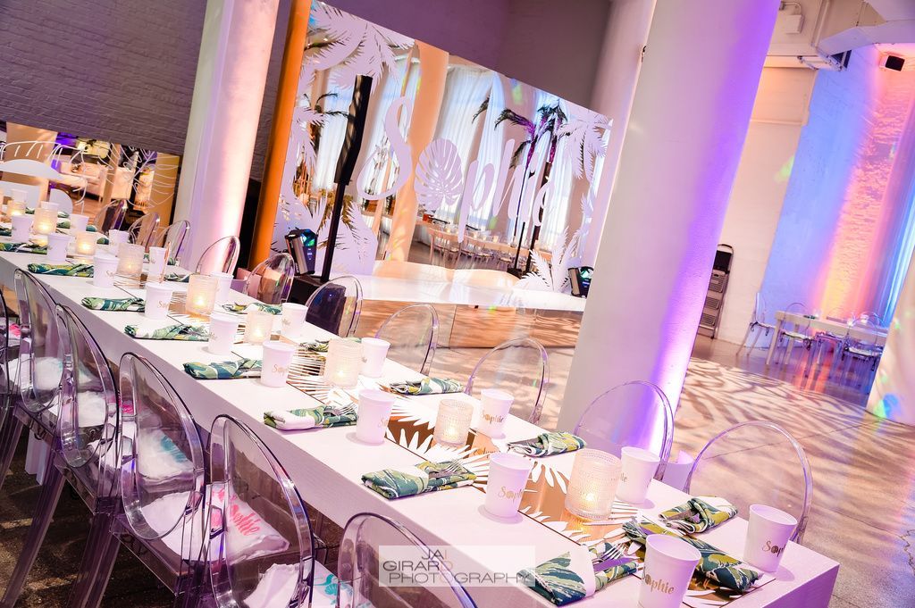 A long table with clear chairs is set up for a party.
