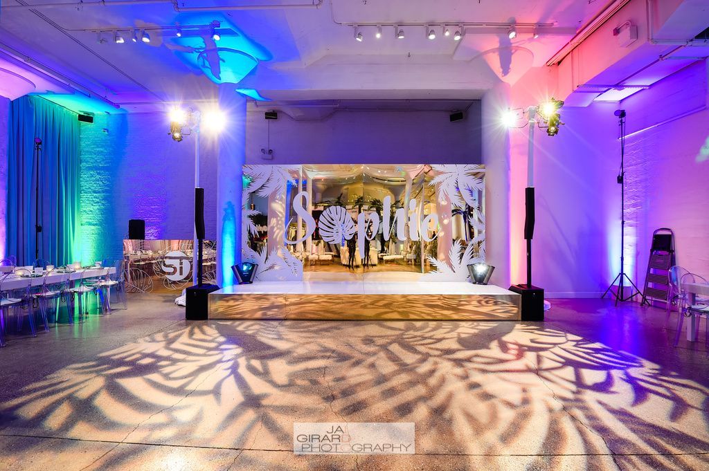 A large room with a stage and a painting on the wall.