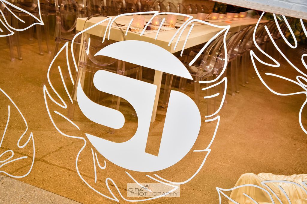 A drawing of leaves and the letter s on a wall