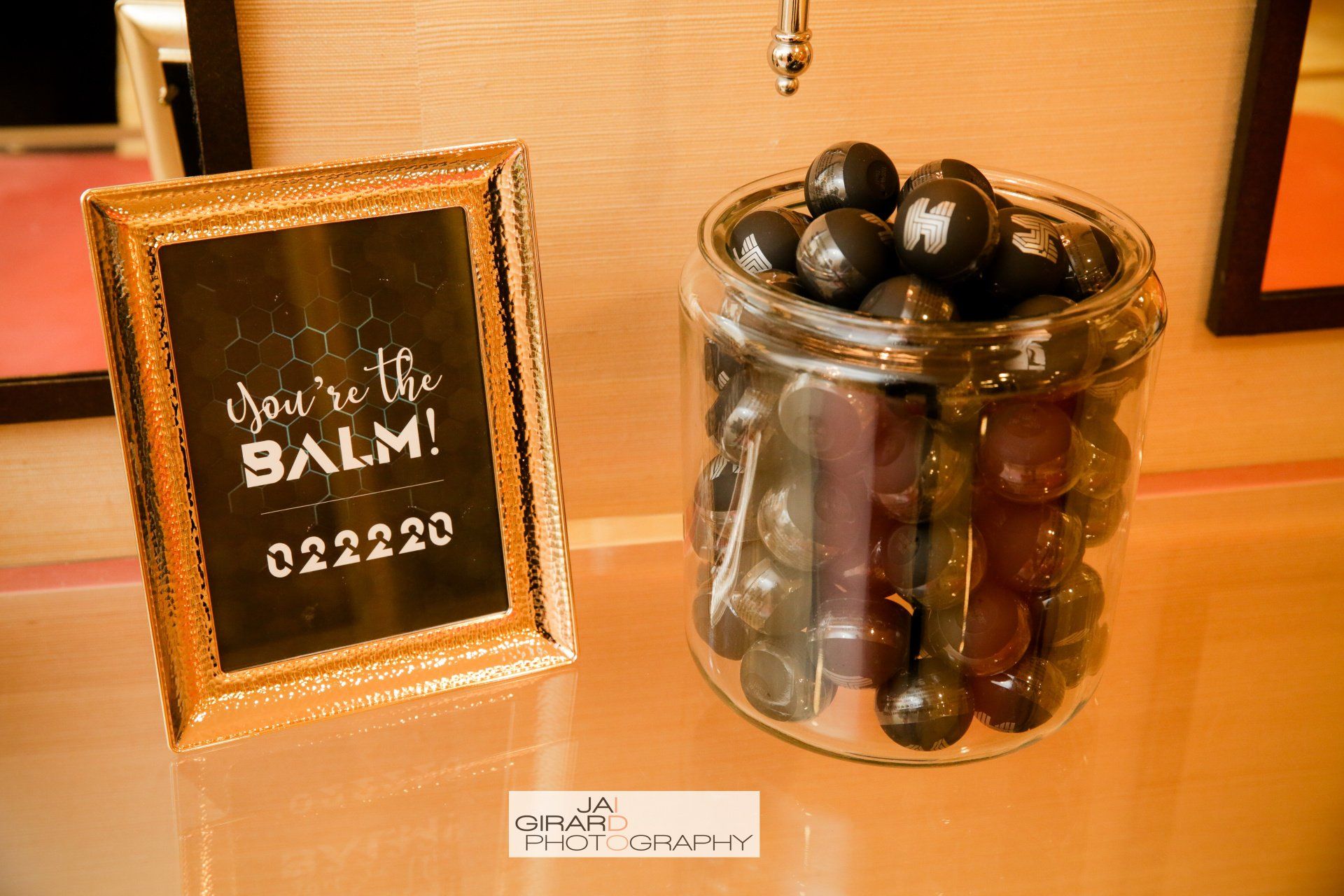 A jar of chocolates next to a sign that says you 're the balm