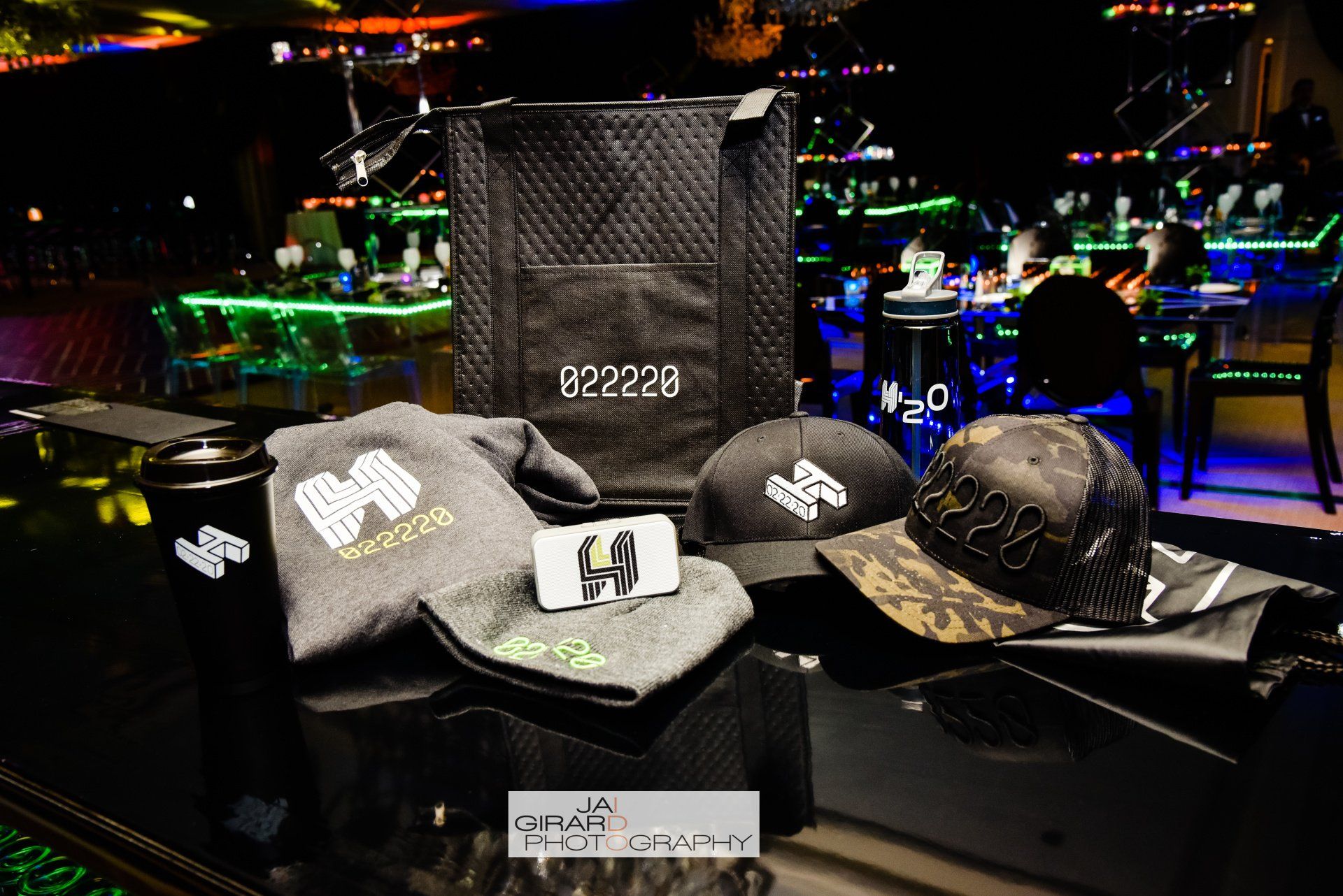 A bunch of hats and shirts are sitting on a table in a dark room.