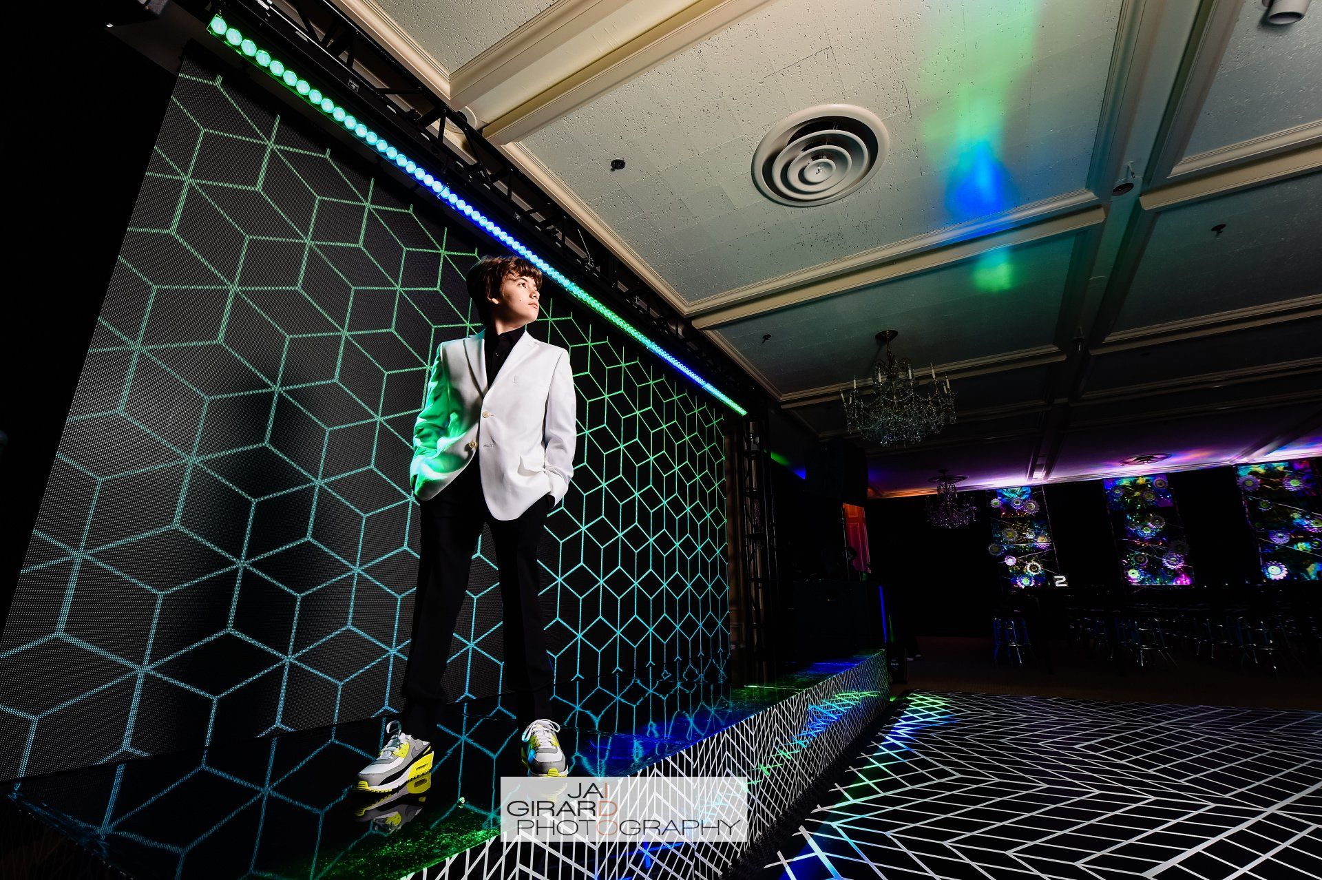 A man in a suit is standing in front of a large screen.