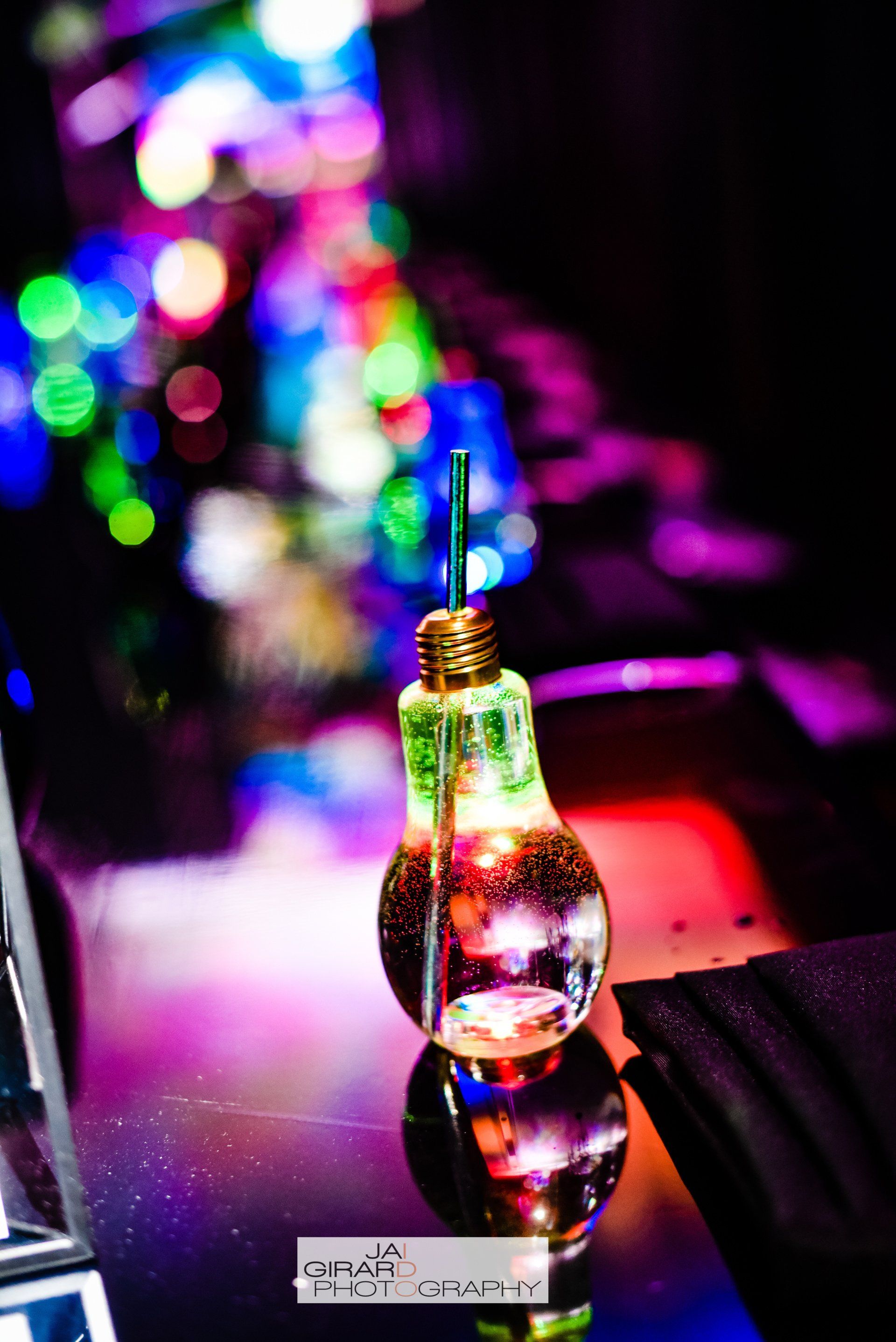 A light bulb shaped drink with a straw in it