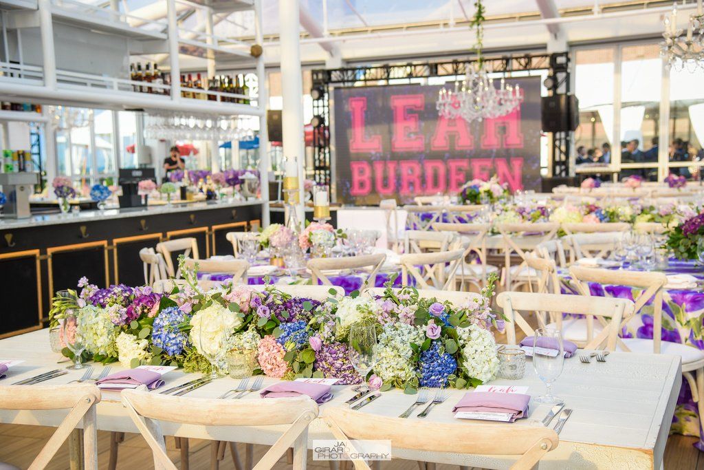 A large room with tables and chairs set up for a party.