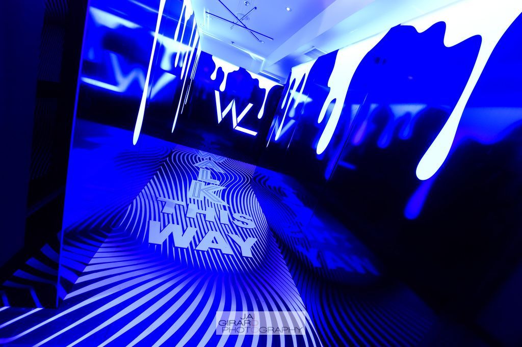 The word way is projected on the floor of a dark room