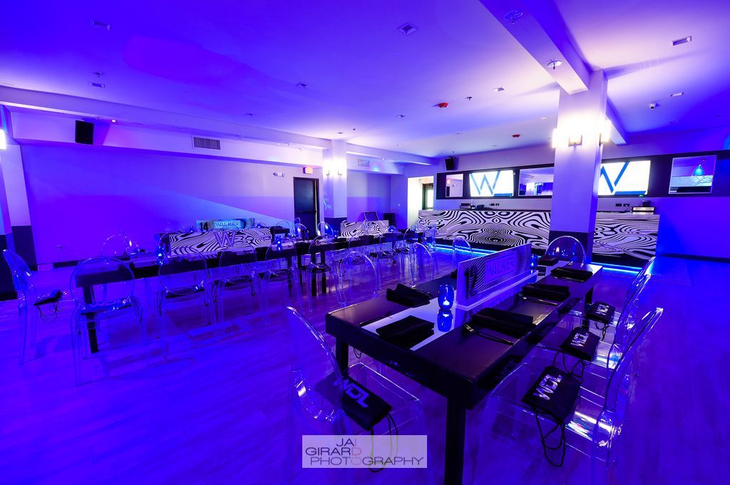 A large room with blue lights and tables and chairs