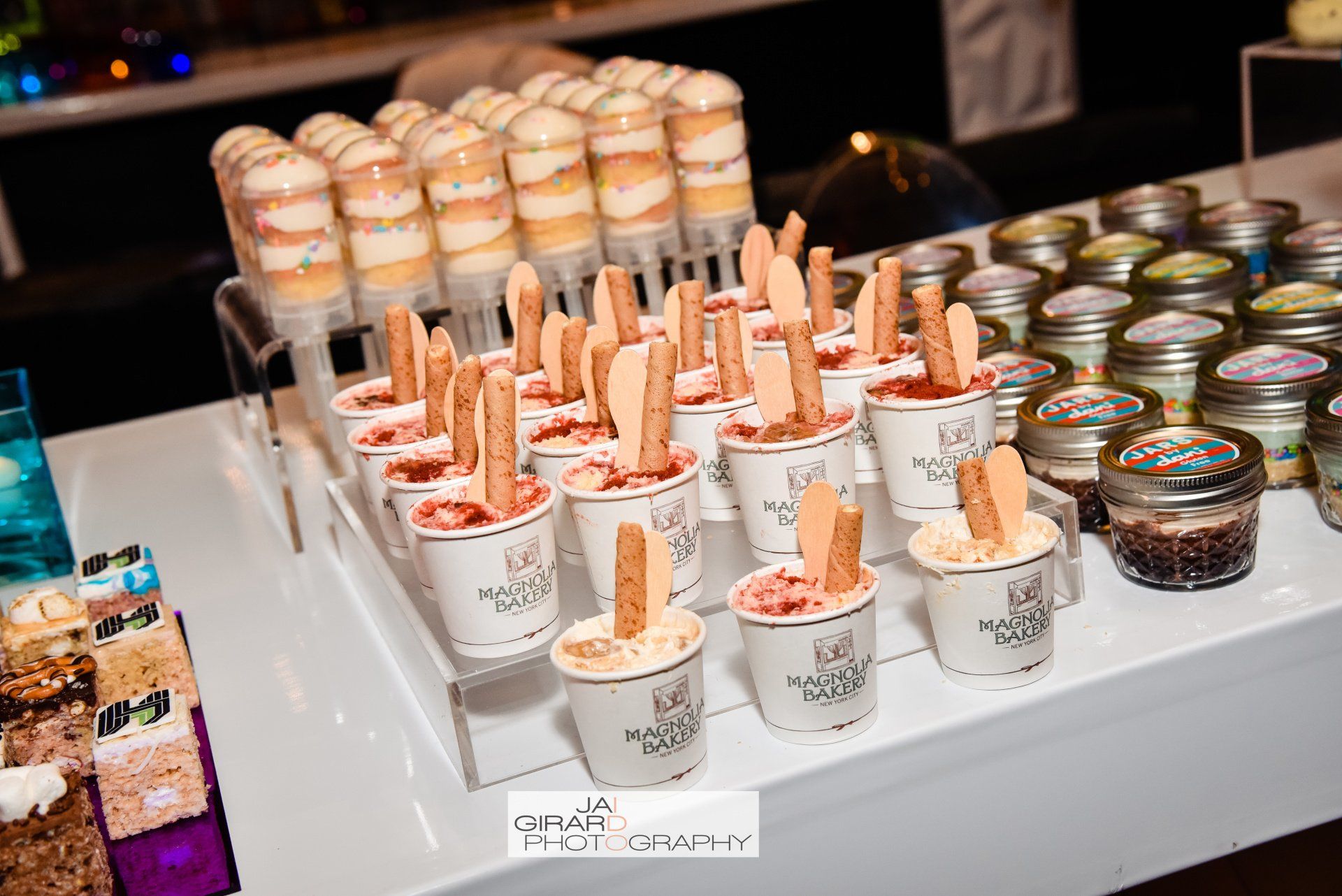 A table topped with a variety of desserts on sticks.