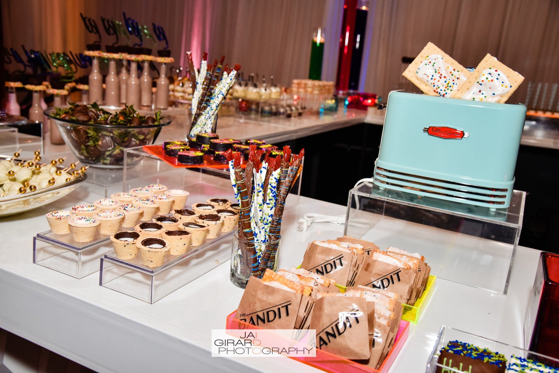 A buffet table with a toaster and a bunch of food on it.