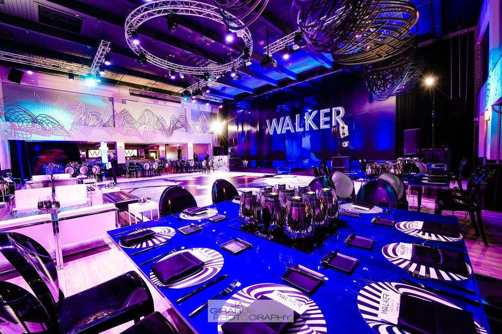 A large room with tables and chairs set up for a party.