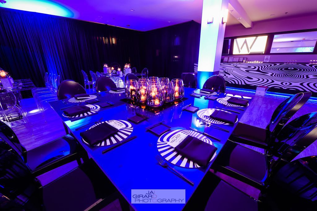 A room with tables and chairs and purple lights