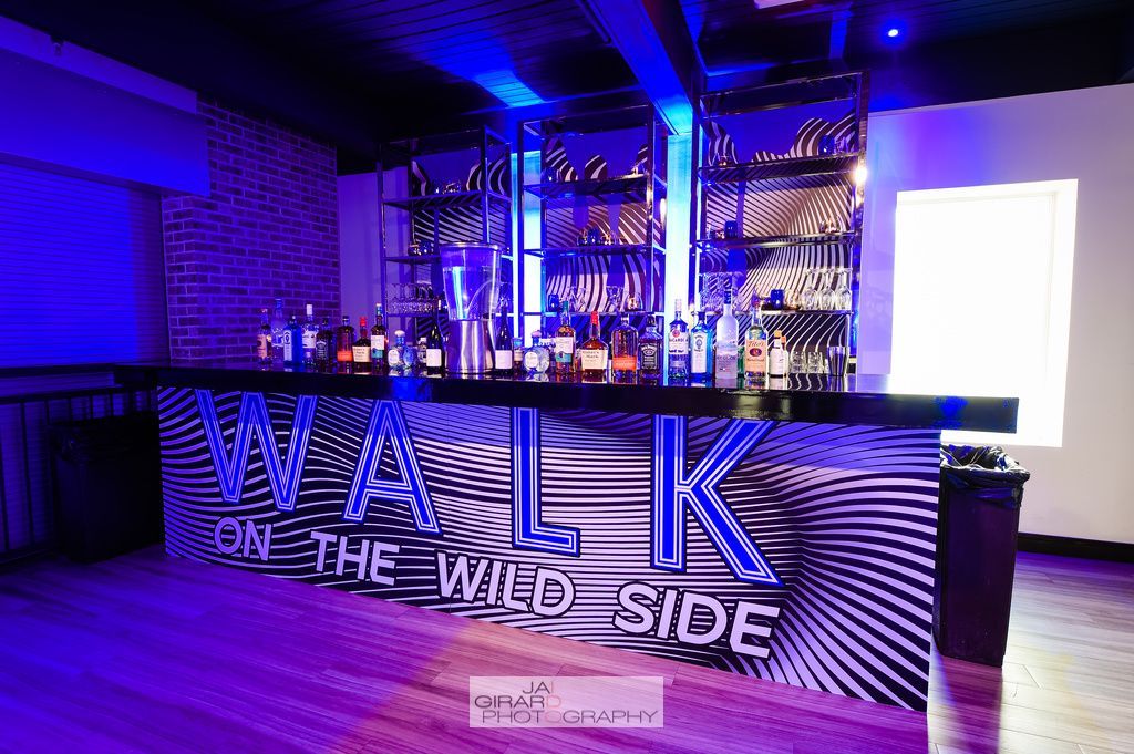 A bar with a sign that says walk on the wild side